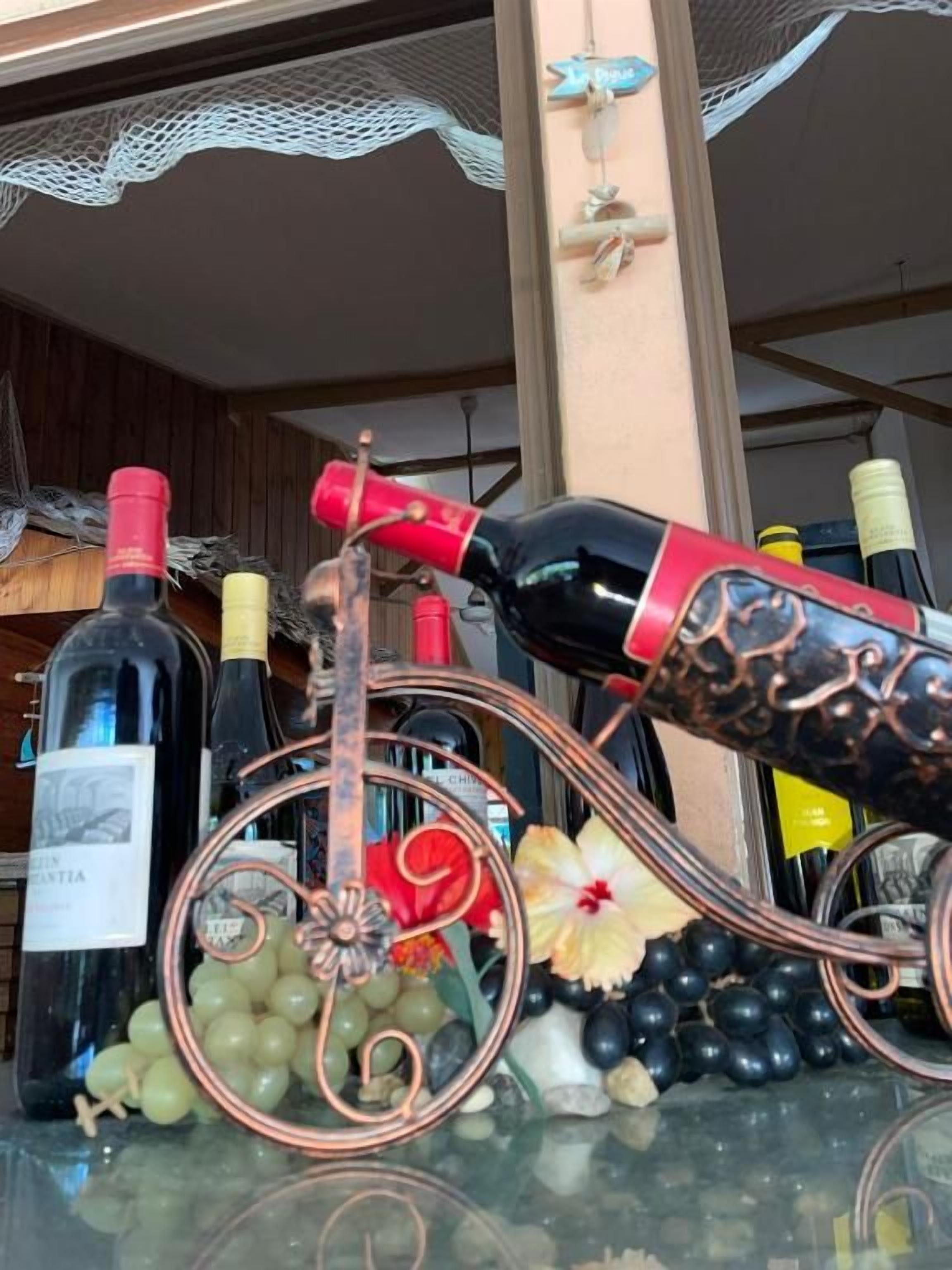 Una botellera con botellas y uvas.