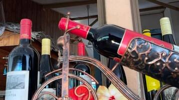 Una botellera con botellas y uvas.