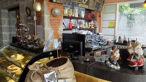 Ein Café mit einer Kaffeemaschine, einer Speisekarte und einer Vitrine mit Gebäck.