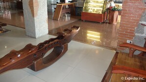 Ein modernes Interieur mit einem Holzschaukelstuhl, einer Glasschiebewand und einer Ziegelwand.