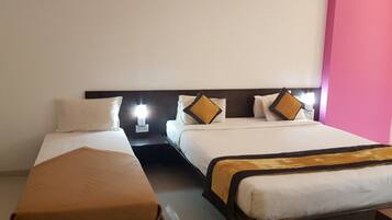 A hotel room with two beds, each with white bedding and decorative pillows.