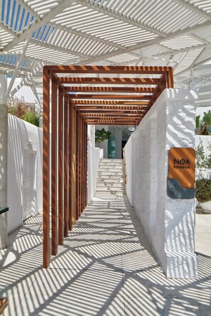 A covered walkway leading to a building with a sign for NOA Restaurant.