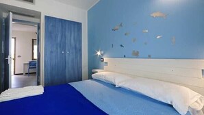 Ein Schlafzimmer mit einem Bett, einer blauen Wand und einer Wanddekoration mit Fischen.