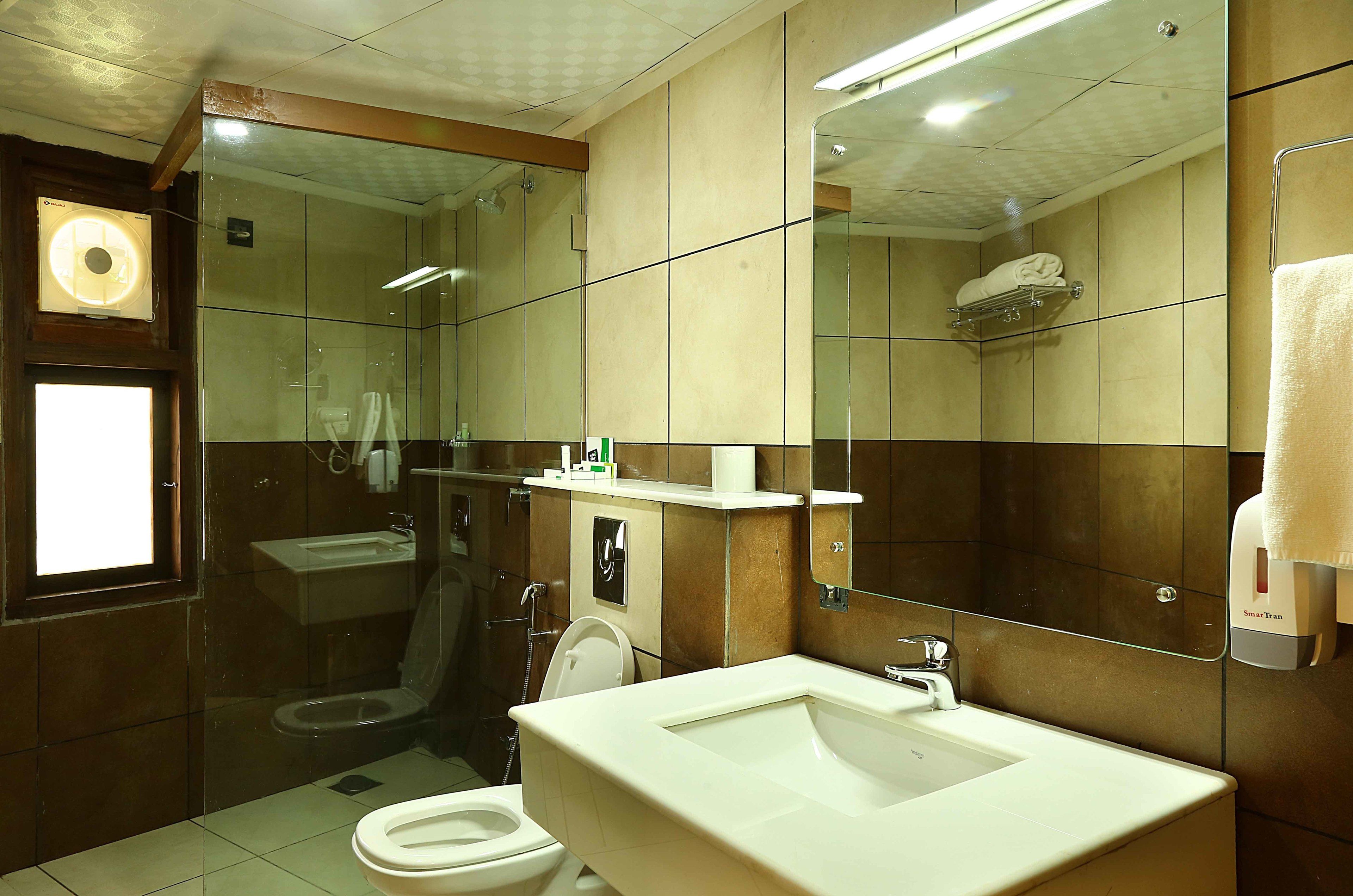 A bathroom with a toilet, sink, and shower.