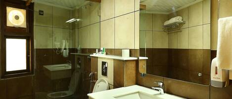 A bathroom with a toilet, sink, and shower.