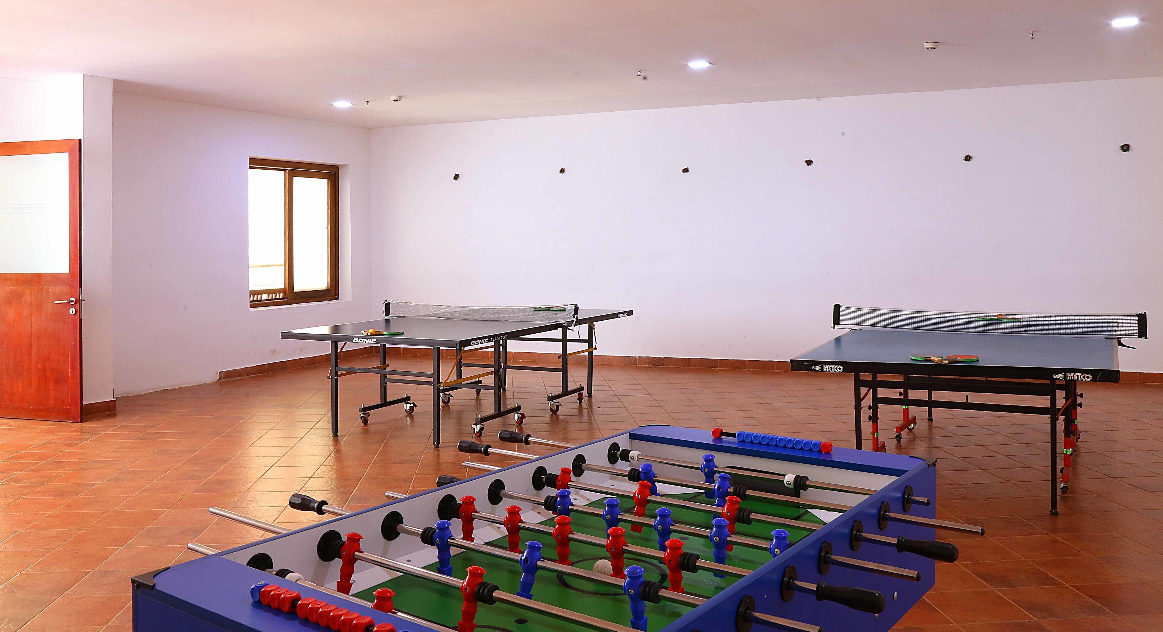 Une pièce équipée d’un baby-foot, d’une table de ping-pong et d’une table de billard.