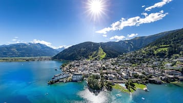 Eine Stadt am Seeufer mit Gebäuden entlang des Ufers, einem klaren Himmel und Bergen im Hintergrund.