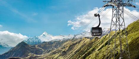 A cable car system with a mountainous backdrop and a clear sky.