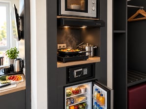 A compact kitchen with a microwave, stove, and refrigerator.