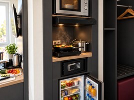 Cozinha compacta com micro-ondas, fogão e geladeira.