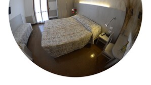 Quarto com cama, mesa de cabeceira, luminária e radiador.