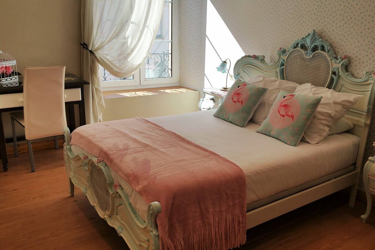 Une chambre à coucher comprenant un lit, une chaise, un bureau et une table de chevet.