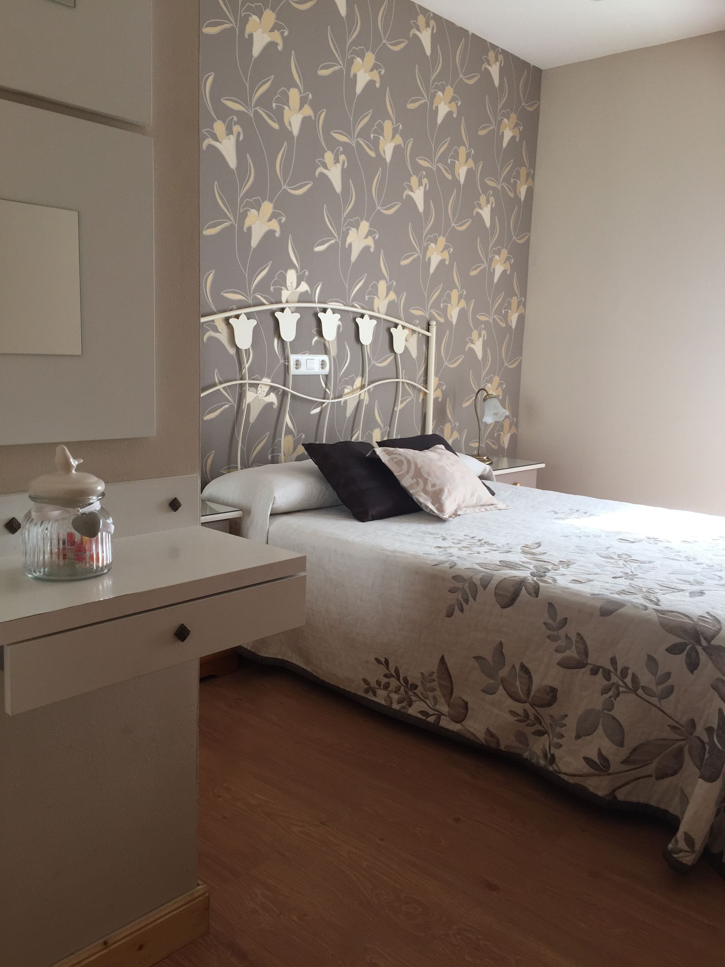 A bedroom with a bed, bedside table, and a nightstand.