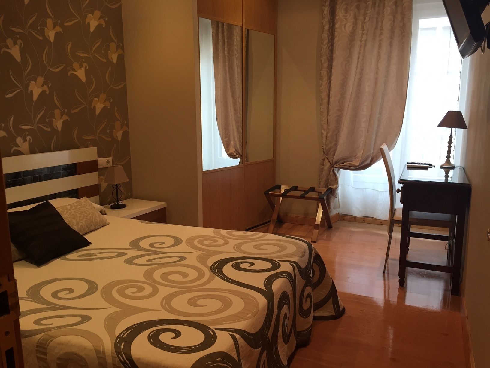 Un dormitorio con una cama, un escritorio y una silla.