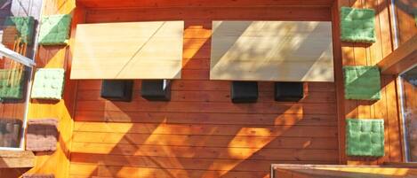 Pared de madera con varias ventanas y cojines verdes.