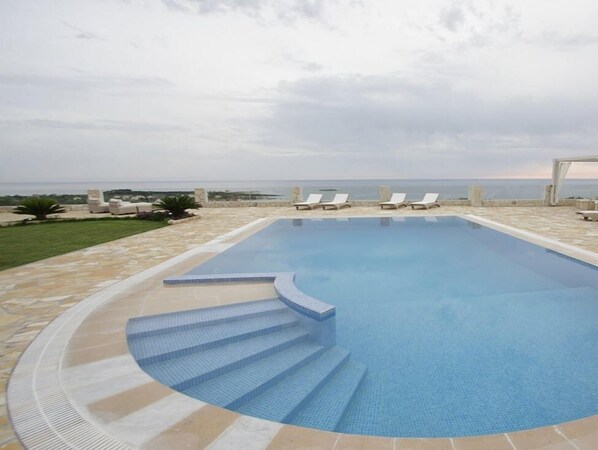 Piscine extérieure, parasols de plage, chaises longues