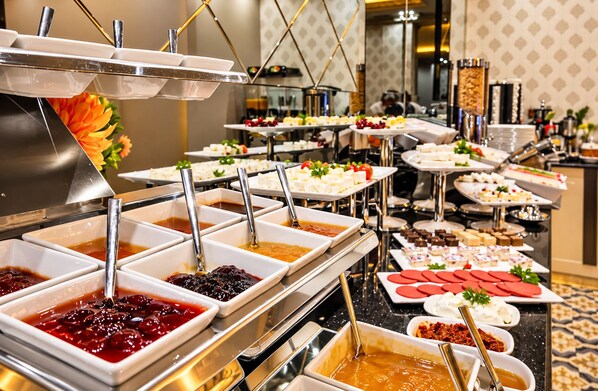A buffet with various food items and condiments. - Real King Residence (Yomra)