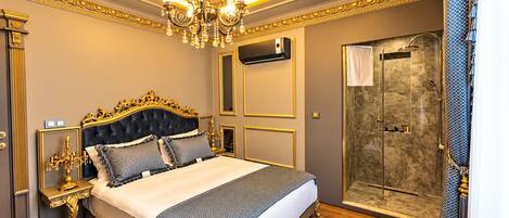 A luxurious bedroom with a large bed, ornate ceiling, and a walk-in shower.
