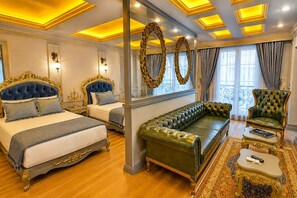 A luxurious bedroom with two ornate beds, a green leather sofa, and a classic armchair. - Real King Residence  (Yomra)