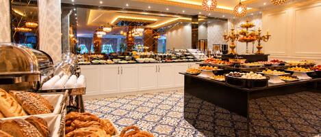 A buffet with various food items, a patterned floor, and a chandelier.