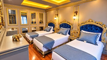 Een luxueuze hotelkamer met drie bedden, gedetailleerde gouden versieringen en een grote spiegel.