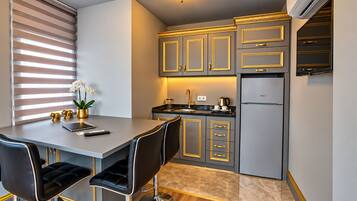 Una cocina moderna con comedor, que incluye una isla de cocina, taburetes de bar y un refrigerador.