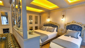 A luxurious bedroom with two beds, ornate headboards, and a large mirror. - Real King Residence  (Yomra)