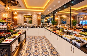 A buffet with a variety of food items and a patterned floor. - Real King Residence  (Yomra)