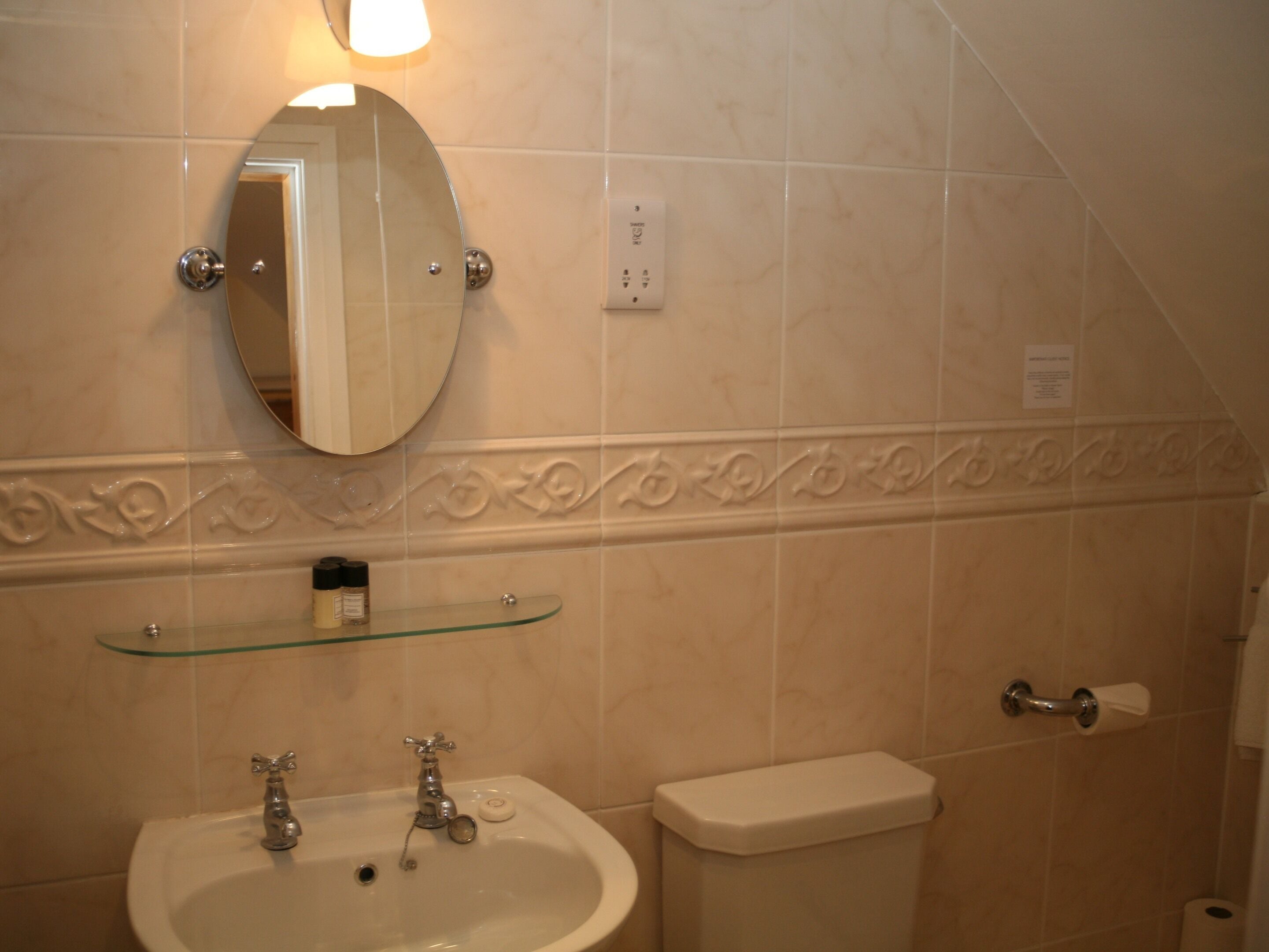 Ein Badezimmer mit Waschbecken, Spiegel und Toilette.