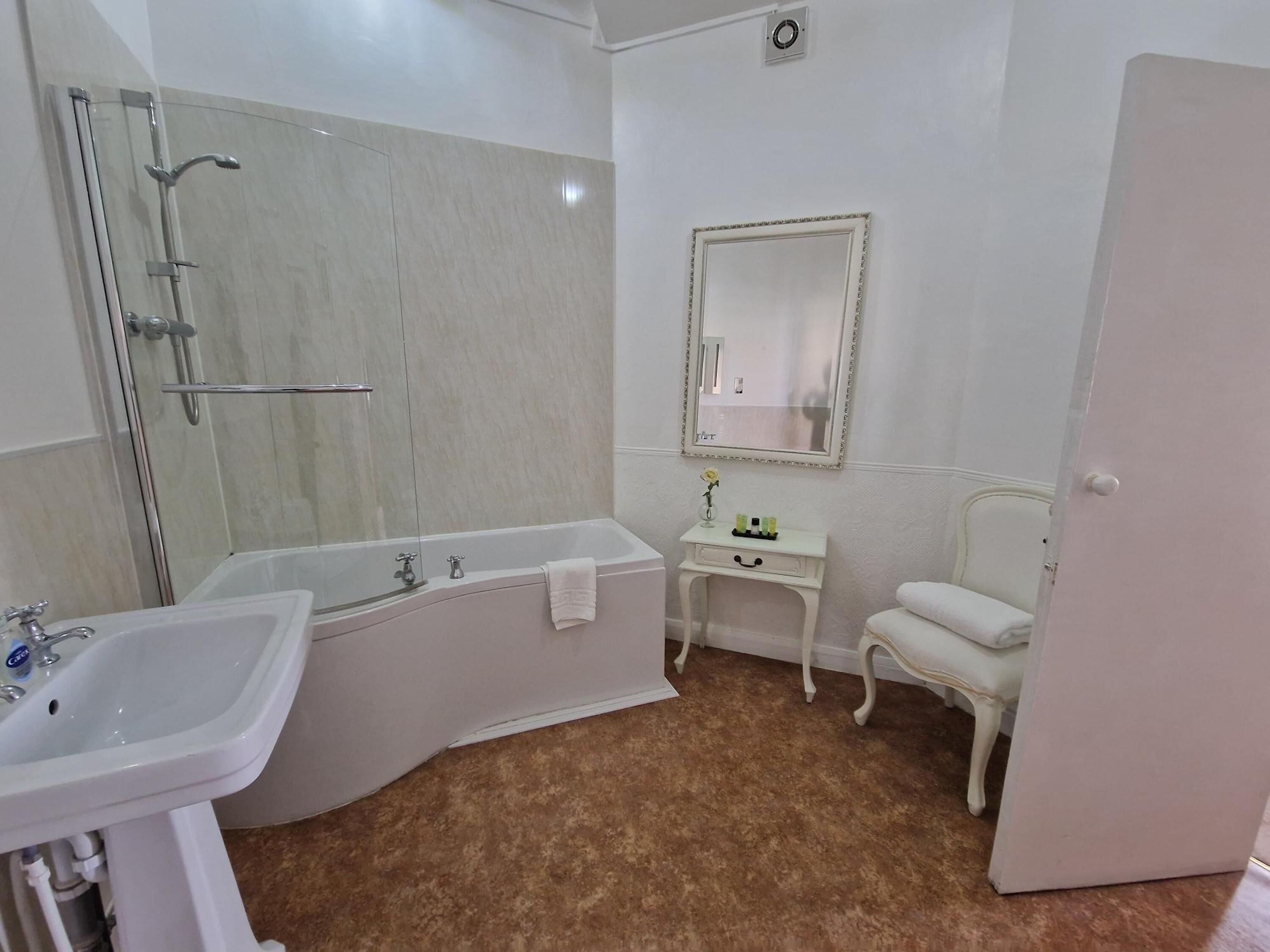 Un baño con bañera, lavabo, tocador con espejo y inodoro.