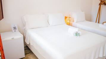 Habitación de hotel con dos camas, una mesita de noche con teléfono y una pequeña mesa con un código QR.
