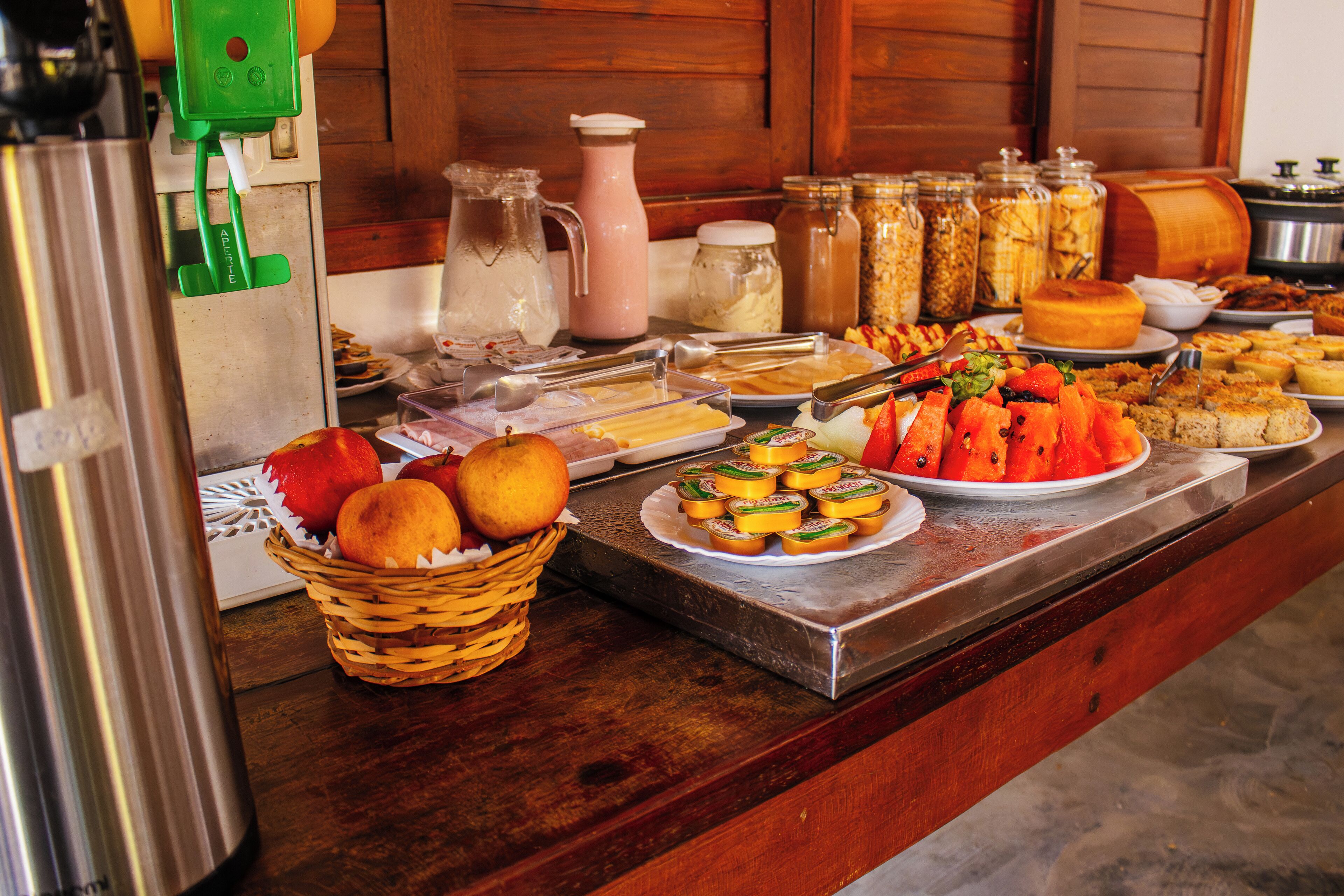 Een buffettafel met diverse soorten eten, waaronder fruit, kazen en gebak.