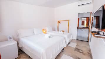 A hotel room with two beds, a desk, a mirror, and a kitchenette.