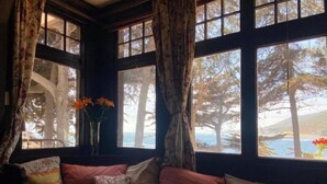 Una habitación acogedora con un ventanal grande, un tablero de ajedrez y un sofá con cojines.