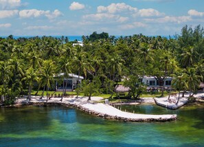 Un resort tropical con aguas cristalinas, palmeras y villas frente a la playa.