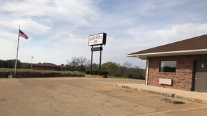 A parking lot with a sign for 'Rosener's Inn' and a flagpole with an American flag. - Rosener's Inn and banquet center (Park Hills)
