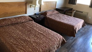 A hotel room with two beds, a desk, a chair, a lamp, and a painting on the wall.