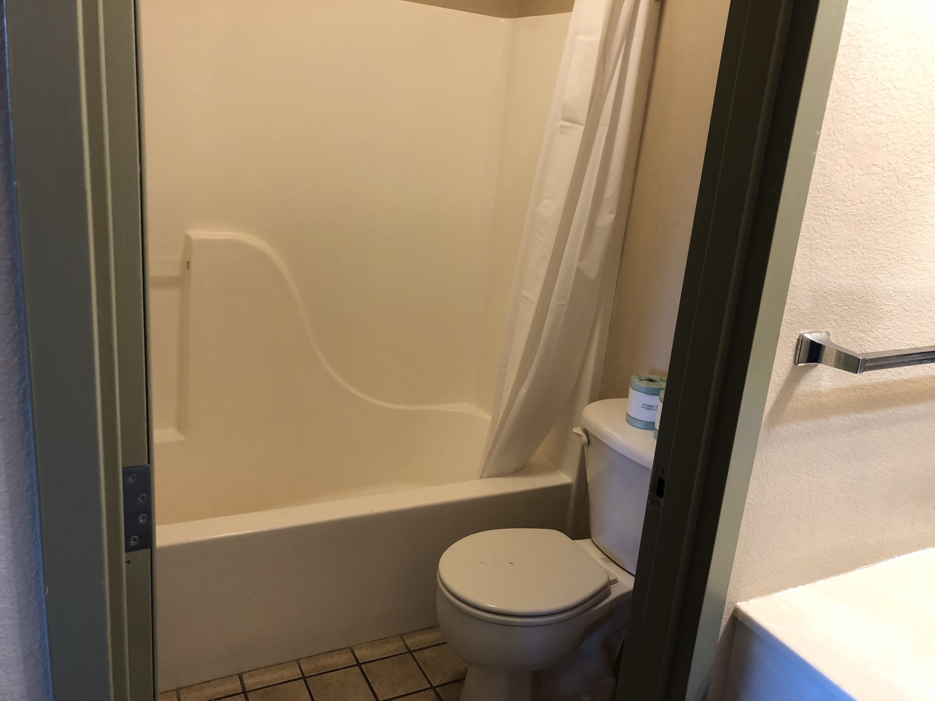 Un baño con bañera, inodoro y cortina de ducha.