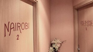 A hotel room with a wooden door labeled "NAIROBI 2". - Basic Confort 2 (San Sebastián)