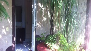 A doorway leading to a room with a tiled floor and a red planter with green plants. - Villa Paraiso (Emiliano Zapata)