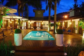 Una piscina al aire libre, sillones reclinables de piscina