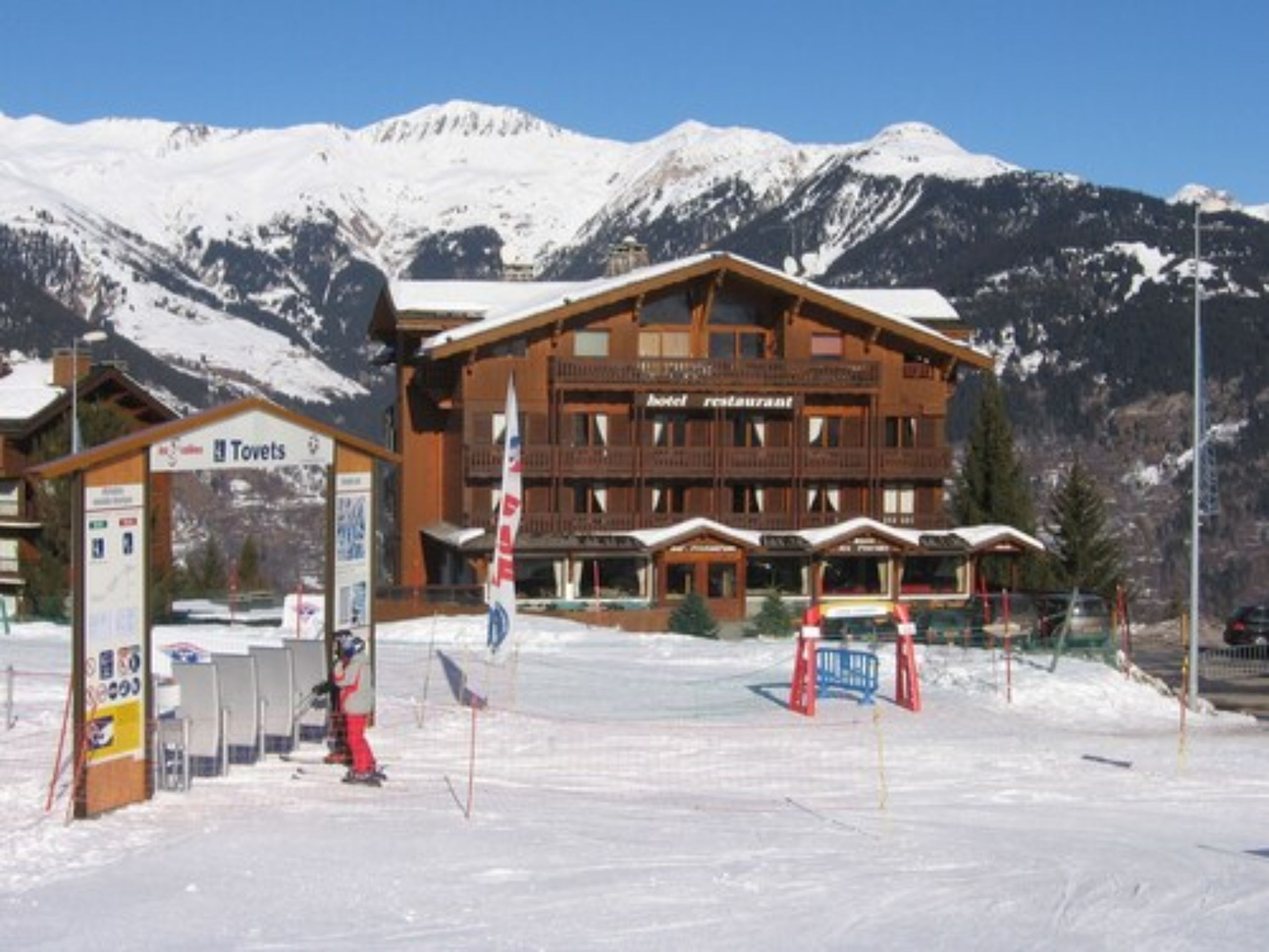 Un hôtel doté d'un restaurant, d'un télésiège et offrant une vue sur les montagnes enneigées.