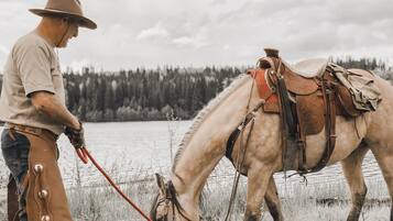 Un hombre montando un caballo con silla de montar y riendas.