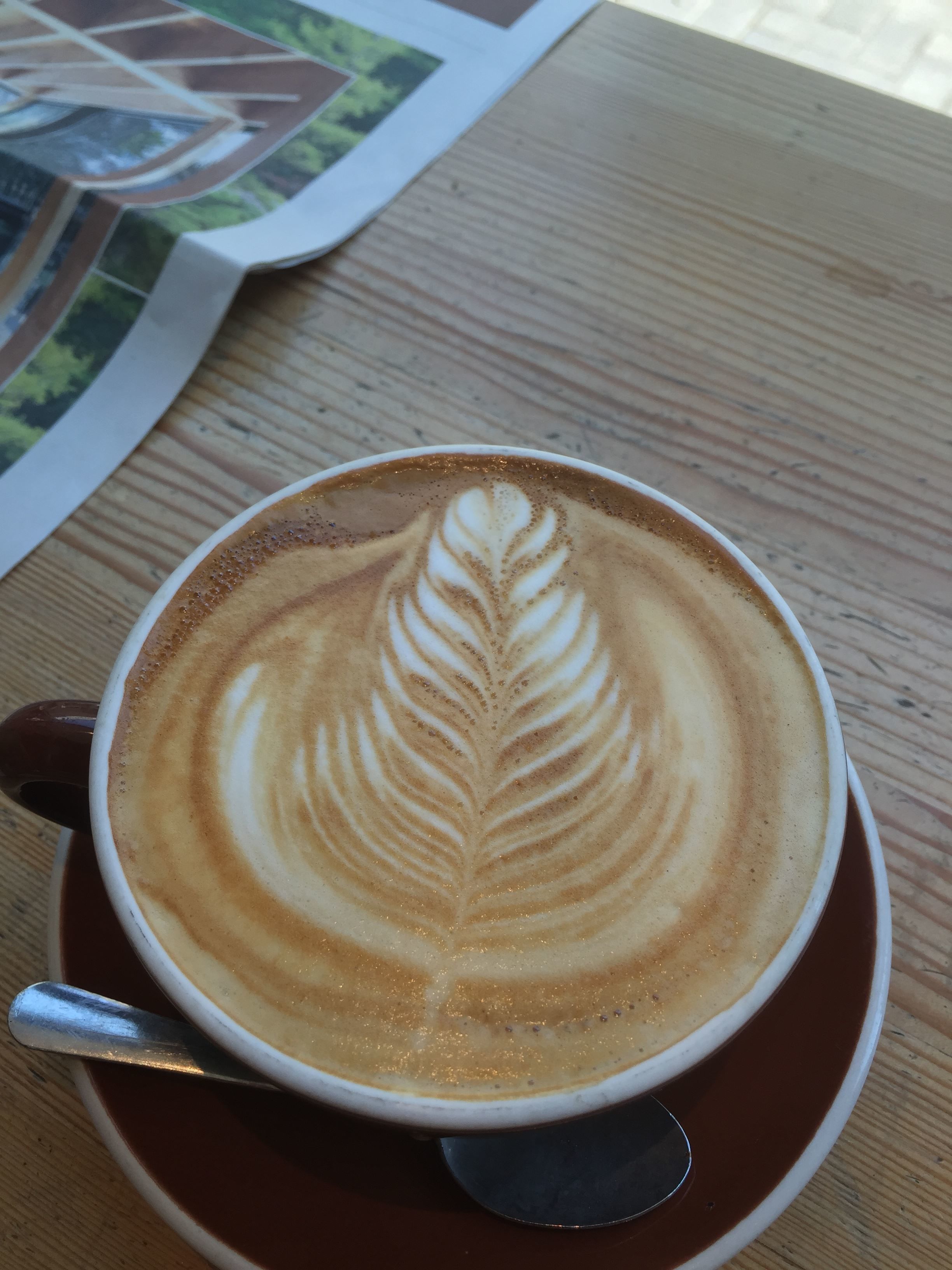 En kop kaffe med latte kunst på et træbord.
