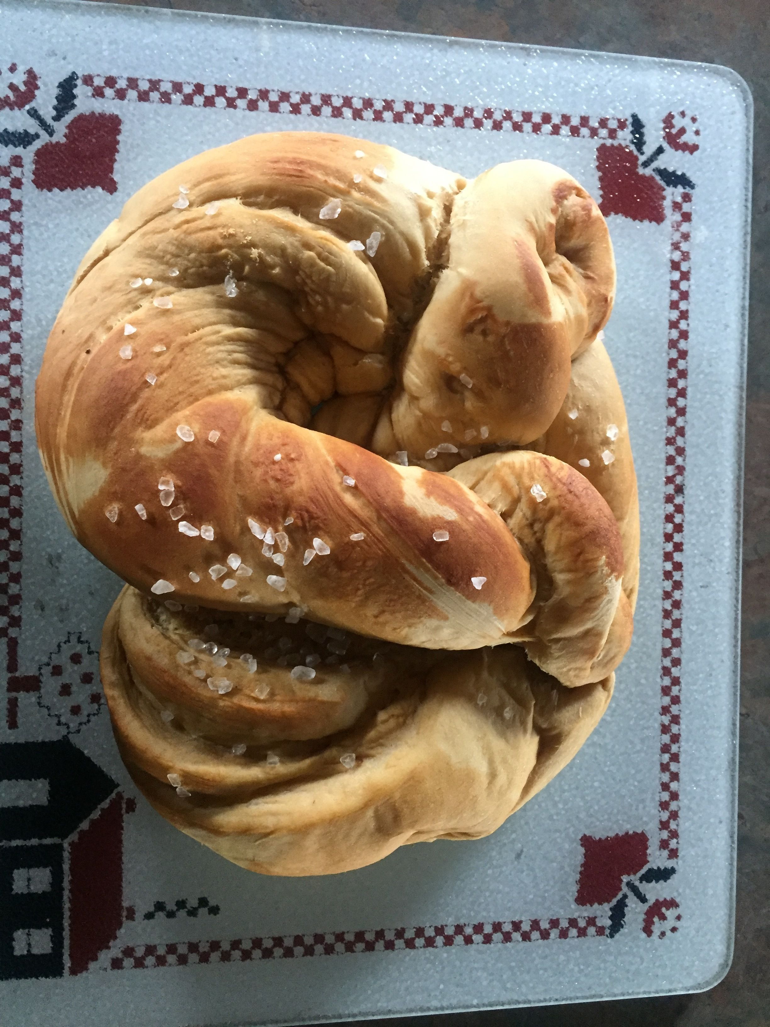 A braided bread with salt on a checkered tray.