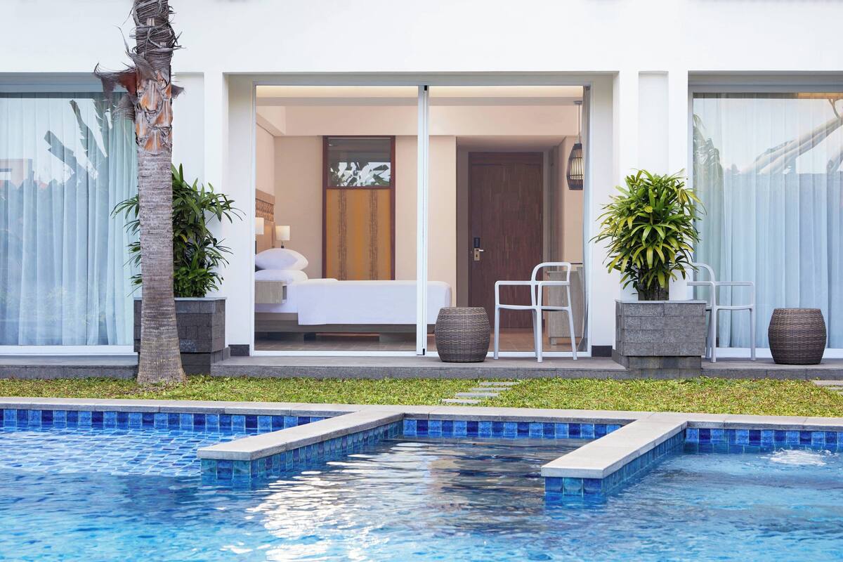 Ein modernes Hotelzimmer mit Balkon, Pool und Meerblick.