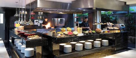 A buffet setup with various food items and stacked plates.