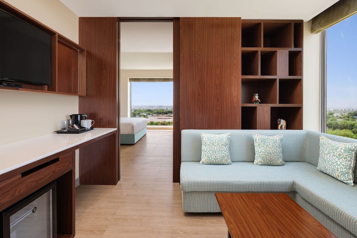 Un salón moderno con sofá, mesa de centro y televisor montado en la pared.