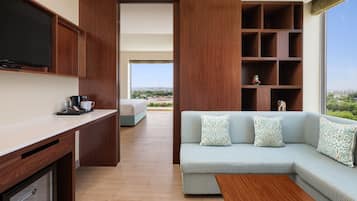 Un espace de vie moderne comprenant un canapé, une table basse et un téléviseur fixé au mur.