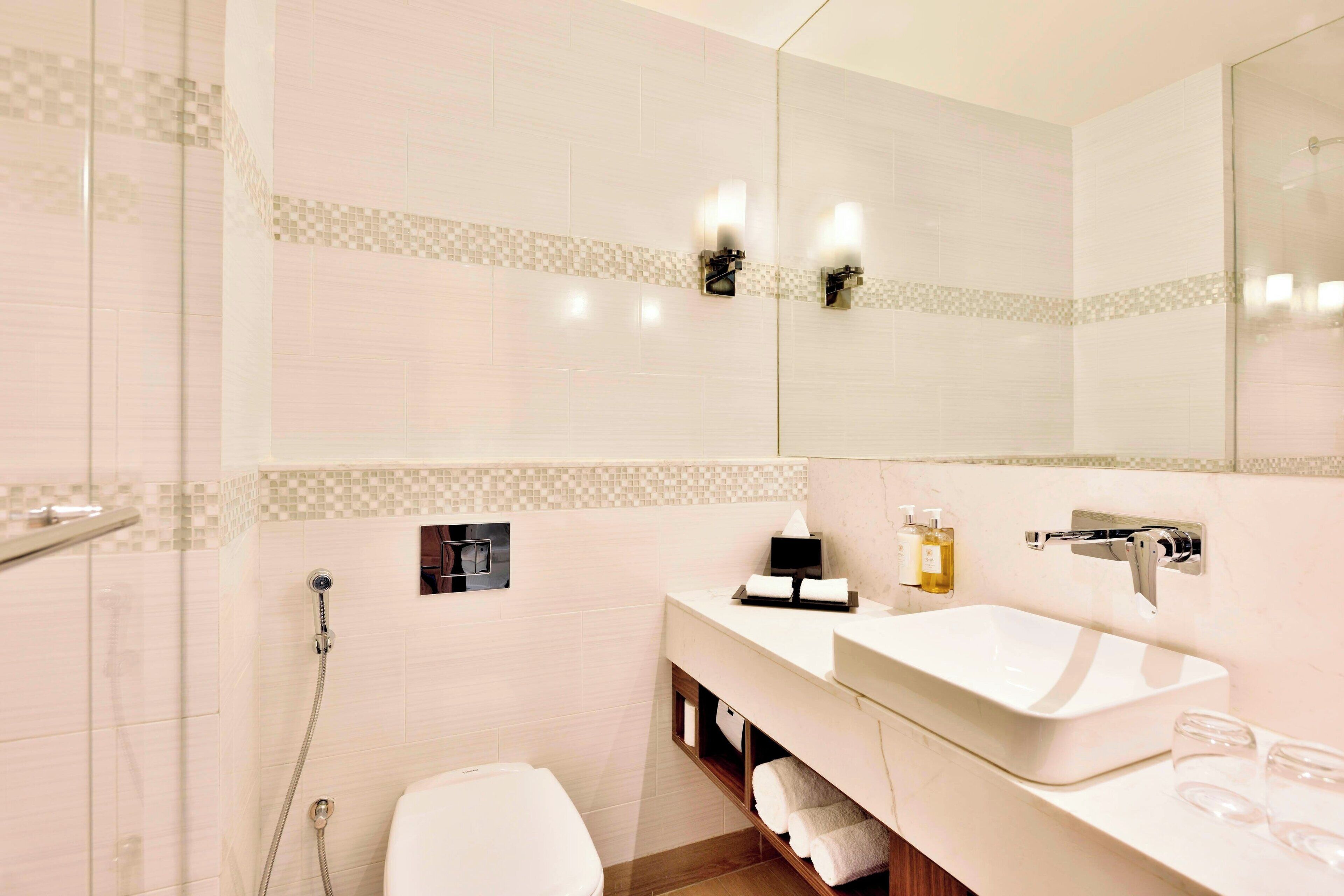 Een moderne badkamer met een wit wastafelmeubel, een spiegel en een douchehoek.